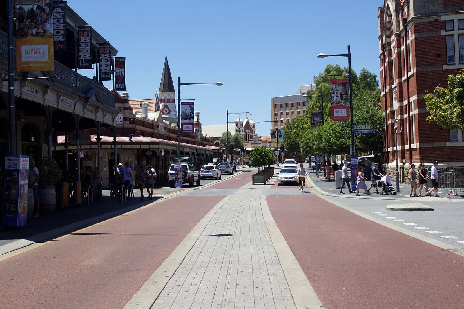 Cafe tables and pedestrians along the heritage shopfronts of the Cappuccino Strip in Fremantle