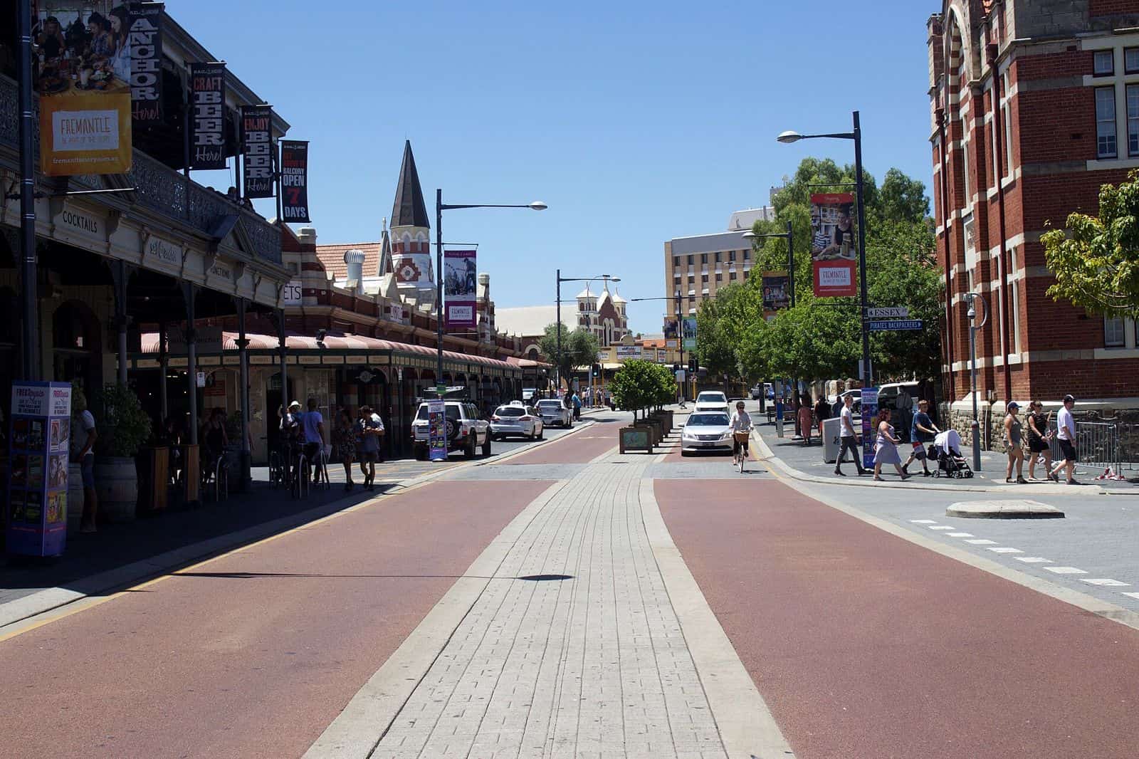 Cafe tables and pedestrians along the heritage shopfronts of the Cappuccino Strip in Fremantle
